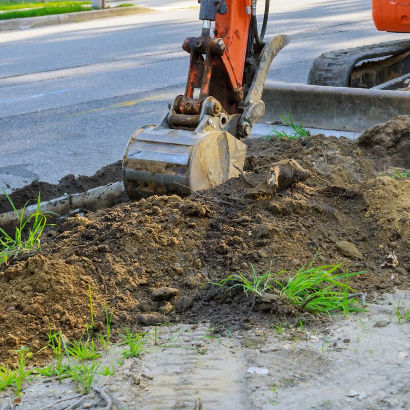 Digger working at construction in excavation pit